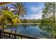 Picturesque view of a serene lake, lush trees, and reflections from a screened-in patio at 19208 Ganton Ave, Lakewood Ranch, FL 34202