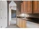 Hall wet bar with stone countertops and wooden cabinets inside a home at 19208 Ganton Ave, Lakewood Ranch, FL 34202