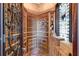 Custom wine cellar with brick flooring, wooden racks, and decorative wrought iron door at 19208 Ganton Ave, Lakewood Ranch, FL 34202