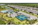 An aerial view showcases a community with a pool, tennis courts, and well-maintained landscaping at 2072 Mackerel St, Port Charlotte, FL 33953