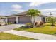 Well-maintained front yard with a lush lawn, a gray brick driveway, and mature landscaping at 2072 Mackerel St, Port Charlotte, FL 33953