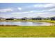 Enjoy serene pond views from this home with lush green landscaping and multiple homes in the distance at 2072 Mackerel St, Port Charlotte, FL 33953