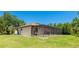Back exterior featuring a screened enclosure, ideal for outdoor living and dining at 222 High Point Dr, Venice, FL 34292