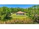 This home boasts a spacious backyard surrounded by lush trees and a pond at 222 High Point Dr, Venice, FL 34292