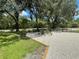 Secluded backyard area with gravel cover and wrought iron table/chairs under the shade trees at 222 High Point Dr, Venice, FL 34292