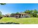 View of the home's rear exterior featuring a spacious screened-in lanai with outdoor seating at 222 High Point Dr, Venice, FL 34292