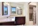 Stylish bathroom featuring a double sink vanity with custom dark wood cabinets and granite countertop at 222 High Point Dr, Venice, FL 34292