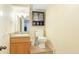 Compact bathroom includes a vanity, toilet, and mirrored cabinet for storage at 222 High Point Dr, Venice, FL 34292
