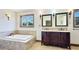 Luxurious bathroom features a double vanity with dark cabinets, and a soaking tub at 222 High Point Dr, Venice, FL 34292