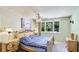 Cozy bedroom with a ceiling fan, a large window offering serene outdoor views, and a bed with blue bedding at 222 High Point Dr, Venice, FL 34292