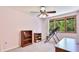Comfortable bedroom with neutral carpet, ample natural light from the window, and classic wooden bookcase at 222 High Point Dr, Venice, FL 34292