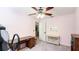 Welcoming bedroom with neutral carpet, a ceiling fan, and a desk for work or study at 222 High Point Dr, Venice, FL 34292