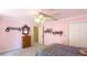 Bright pink bedroom showcasing carpeting, ceiling fan, and a light-filled view to the outdoors at 222 High Point Dr, Venice, FL 34292