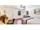 Bright bedroom with hardwood floors features ceiling fan, desk and a white door to the backyard at 222 High Point Dr, Venice, FL 34292
