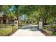 Grand entrance with a long driveway framed by mature trees, leading to a beautifully landscaped property at 222 High Point Dr, Venice, FL 34292