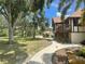 Beautiful exterior with large trees and a walkway leading to the home's entrance at 222 High Point Dr, Venice, FL 34292