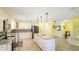 Bright kitchen featuring island with seating, stainless appliances and white cabinetry at 222 High Point Dr, Venice, FL 34292