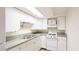 Bright kitchenette features white cabinets, stainless steel sink, and essential appliances at 222 High Point Dr, Venice, FL 34292