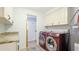 Spacious laundry room with modern washer and dryer units plus granite countertops at 222 High Point Dr, Venice, FL 34292