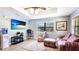Cozy living room with tile flooring, a ceiling fan, an exterior view, and comfortable furniture at 222 High Point Dr, Venice, FL 34292
