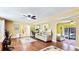 Open-concept living room with wood floors, ceiling fan, and seamless flow to backyard at 222 High Point Dr, Venice, FL 34292