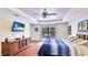 Main bedroom with hardwood floors, tray ceilings, ample natural light, and an entertainment center at 222 High Point Dr, Venice, FL 34292