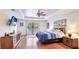 Main bedroom with hardwood floors, tray ceilings, ample natural light, and an entertainment center at 222 High Point Dr, Venice, FL 34292