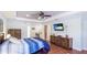 Spacious primary bedroom with hardwood floors, tray ceilings, ample natural light, and an entertainment center at 222 High Point Dr, Venice, FL 34292