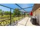 Covered patio boasts stone flooring, grill, outdoor seating and views of the backyard at 222 High Point Dr, Venice, FL 34292