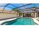 Enclosed pool features an integrated hot tub and backyard views at 222 High Point Dr, Venice, FL 34292