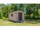 A storage shed provides extra space for tools and garden equipment in a serene, green backyard setting at 222 High Point Dr, Venice, FL 34292