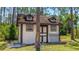 Cozy storage shed with dormer windows, set amidst a wooded backyard at 222 High Point Dr, Venice, FL 34292