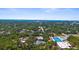 Distant aerial shot with the home's roof amidst the greenery, cityscape, and seascape visible in the distance at 2632 Hawthorne St, Sarasota, FL 34239