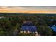Aerial view of the property with lush trees, beautiful landscaping and a glimpse of the sunset at 2632 Hawthorne St, Sarasota, FL 34239