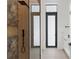 Modern bathroom featuring a glass-enclosed shower with a wooden tile accent wall and dark fixtures and fittings at 2632 Hawthorne St, Sarasota, FL 34239