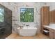 Spa bathroom featuring freestanding tub, vanity, and window with a leafy view at 2632 Hawthorne St, Sarasota, FL 34239
