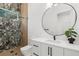 Modern bathroom featuring stylish vanity, round mirror, and a glass-enclosed shower with decorative tile at 2632 Hawthorne St, Sarasota, FL 34239