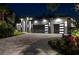 Stunning modern home with a two-car garage, lush landscaping, and elegant exterior lighting at night at 2632 Hawthorne St, Sarasota, FL 34239