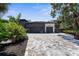 Modern home with a large paver driveway leading to a two-car garage surrounded by lush landscaping at 2632 Hawthorne St, Sarasota, FL 34239