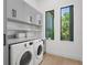 Bright laundry room featuring modern appliances, storage cabinets, and natural light at 2632 Hawthorne St, Sarasota, FL 34239