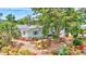 Aerial view of a home surrounded by lush landscaping with palm trees and bromeliads, and a manicured lawn at 3036 Rose St, Sarasota, FL 34239