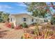 The home features meticulous landscaping with mulch, bromeliads, and a well-maintained exterior with blue shutters at 3036 Rose St, Sarasota, FL 34239