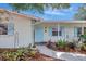 Charming single-story home with a light exterior and lush, well-maintained front yard landscaping and a baby blue front door at 3036 Rose St, Sarasota, FL 34239