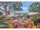 Charming home with beautiful landscaping, featuring mature trees and colorful bromeliads at 3036 Rose St, Sarasota, FL 34239