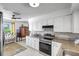 Well-lit kitchen with stainless steel appliances, granite counters, and white cabinets at 3036 Rose St, Sarasota, FL 34239