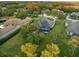 Aerial view of a property with a screened-in pool, surrounded by trees and green spaces in a residential area at 3415 162Nd E Ave, Parrish, FL 34219