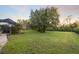 Large backyard with a screened-in pool area, mature trees, and lush green lawn for outdoor enjoyment at 3415 162Nd E Ave, Parrish, FL 34219