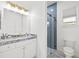 Modern bathroom with blue tiled shower, granite countertop, and stylish gold fixtures at 3415 162Nd E Ave, Parrish, FL 34219