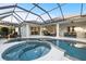 Beautiful screened-in pool and spa with ample seating and lounging areas, seamlessly connected to the home's indoor spaces at 3415 162Nd E Ave, Parrish, FL 34219