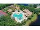 Beautiful aerial view of a community pool with lounge chairs and a playground surrounded by lush trees at 356 Blackbird Ct, Bradenton, FL 34212